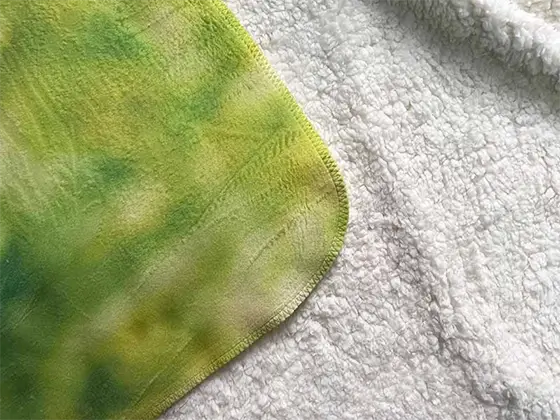 Detail van de bedrukte zijde en zachte schapenvachtlook van de deken