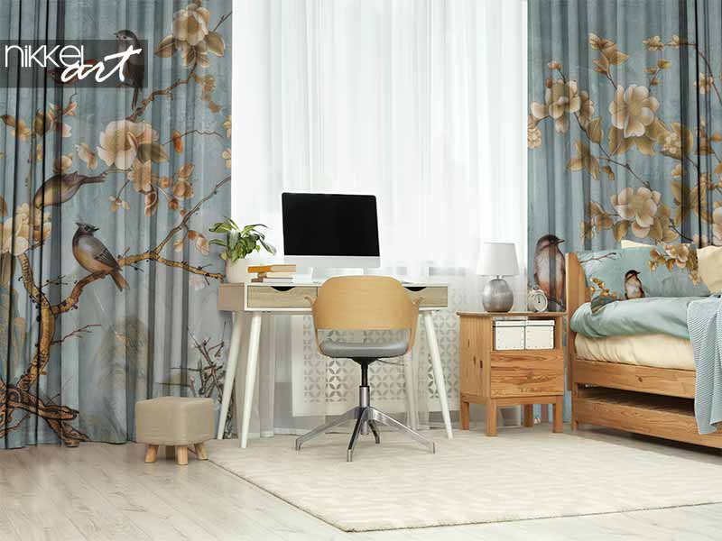 Blauwgrijze gordijnen met bloemen- en vogelmotief in een werkkamer met houten meubels