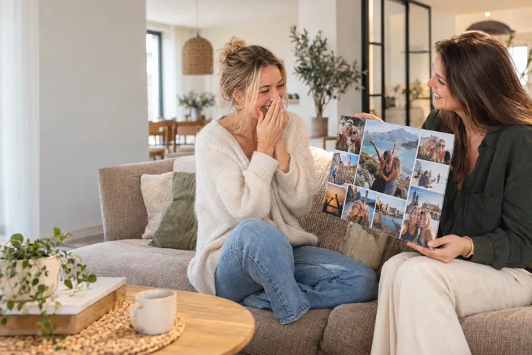 Twee vriendinnen bekijken een persoonlijke fotocollage van hun reizen