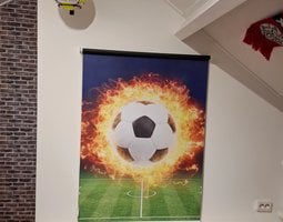 Rolgordijnen Brandende voetbal boven groen stadion